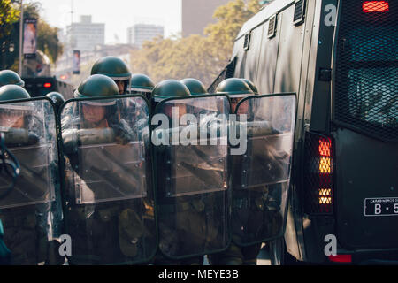 Santiago, Chile - 19. April 2018: eine Linie der chilenischen Polizei beobachten Demonstranten während einer Demonstration in der Innenstadt von Santiago, Chile. Die Demonstranten Stockfoto