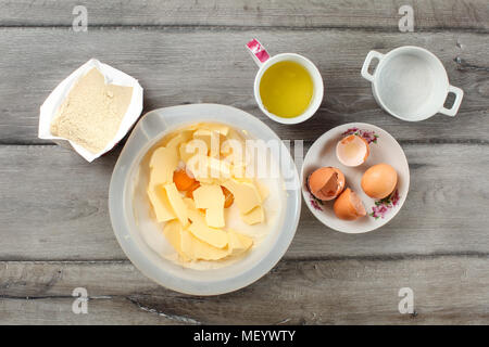 Table Top Blick auf Zutaten für Kuchen Vorbereitung. Sack Mehl, Schüssel mit Butter und Eigelb, Tasse mit glair, Eierschalen und Zucker, auf gr Stockfoto