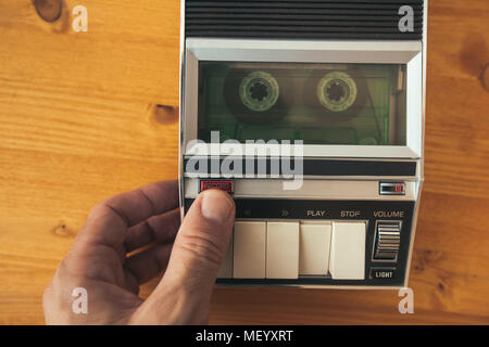 Finger Drücken der Aufnahmetaste auf vintage Audio Cassette player, Ansicht von oben. Polizeibefragung Tonaufnahme retro Technologie Konzept für 1970 s Stockfoto