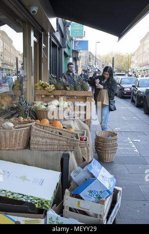 Käufer durchsuchen durch Obst für den Verkauf am Broadway Market, ein Markt in Hackney, East London, Großbritannien, 29. Oktober 2017. () Stockfoto