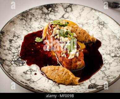 Mittagessen im Hotel Blow Up 5050, Posen. Schweinefuß kombiniert mit Sauerkraut und Erbsenpüree und einer malzigen dunklen Biersauce. Die Belag besteht aus poppten Schweinehaut Stockfoto