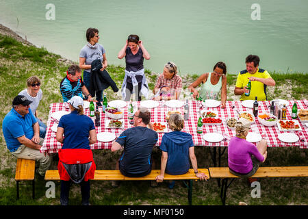 Wandermarathon durch die Toskana. Gruppe von Wanderern, die im Sommer ein Picknick an einem Teich in der Nähe von Montalcino, Toskana, Italien, machen Stockfoto