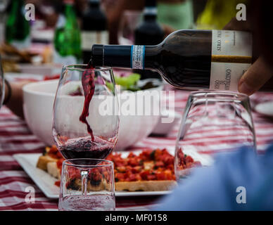 Sommerpicknick in der Toskana, Nahaufnahme einer Flasche Rotwein in ein Glas, Wein von Montalcino, einem berühmten Weinhersteller Stockfoto
