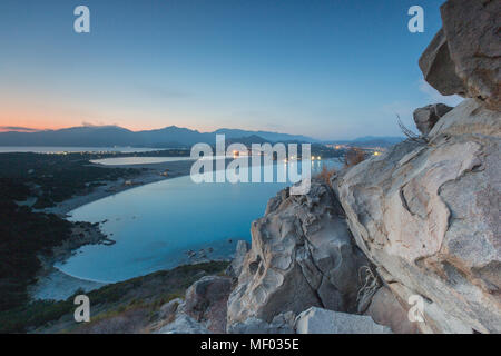 Top Aussicht auf die Bucht mit sandigen Stränden und Lichter eines Dorfes in der Abenddämmerung Porto Giunco Villasimius Cagliari Sardinien Italien Europa Stockfoto