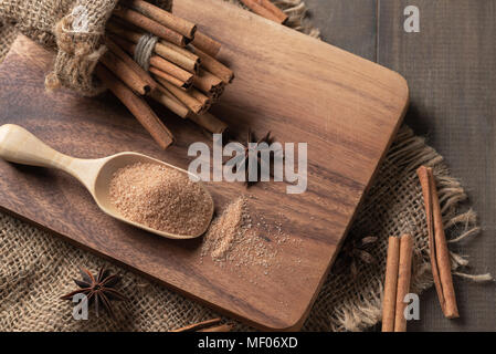Zimtpulver mix Zucker auf Holz Lufthutze und Cinnamon Sticks mit Sternanis Gewürz auf den Holzklotz, Ansicht von Oben, Gewürze und Kräuter Konzept Stockfoto