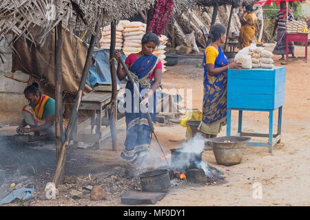 Thanjavur, Indien - 13. März 2018: Frauen verkaufen cashewnüsse am Straßenrand. Die Gehäuse sind beheizt, so dass die Muttern leicht geschält werden kann. Stockfoto