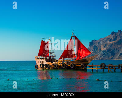 Holz- Schiff mit roten Segeln auf der Pier Stockfoto