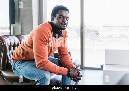 Portrait von zuversichtlich casual Geschäftsmann sitzen auf der Couch Stockfoto