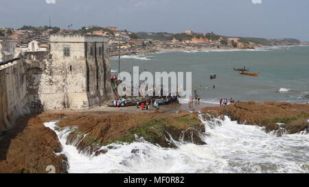 Fischerboote und die Leute am Strand in der Nähe des Fort in Cape Coast, Ghana Stockfoto