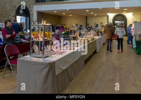 Käufer gehen um die Markthalle an den Ständen mit Kunsthandwerk in der Kornmarkt, Cirencester, Gloucestershire, England, UK suchen Stockfoto