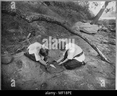 Schwarz-weiß Foto von zwei Frauen im Freien, einen Fisch zum Backen durch Reiben weichem Ton, 1905. Mit freundlicher Genehmigung Internet Archive. () Stockfoto