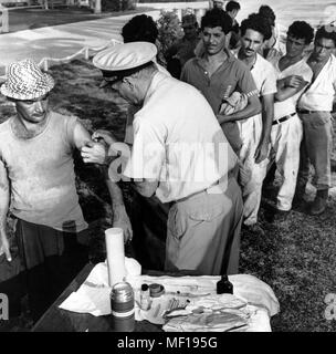 U.S. Public Health Service (PHS) Repräsentative immunisierenden eine Kubanische Mann, Kubanische Masse - Auswanderung, Miami, Florida, Oktober, 1965. Mit freundlicher Seuchenkontrollzentren (CDC). () Stockfoto