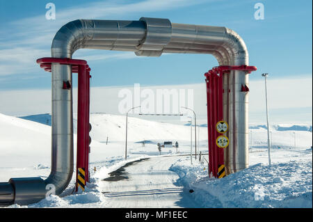 Winterlandschaft. Bunte Rohrleitungen Brückenbauwerk über die Straße an der Krafla Geothermie-Kraftwerke in Island gebaut Stockfoto