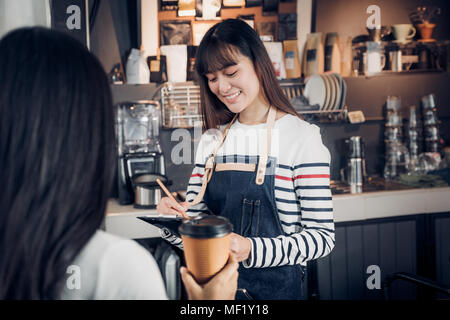 Asien Barista Kellner um von Kunden im Coffee Shop, cafe Besitzer schreiben Drink an der Bar, Essen und Trinken, Geschäftskonzept, Service Verstand Stockfoto