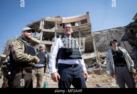 24 April 2018, Irak, Mosul: Entwicklungsministerin Gerd Mueller der Christlich Sozialen Union (CSU) steht vor einem Krankenhaus, die durch den islamischen Staat zerstört wurde. Das Krankenhaus diente als Sitz. Foto: Kay Nietfeld/dpa Stockfoto