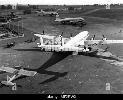 Eine Lockheed Super Constellation "Flugzeug von einem niederländischen Fluggesellschaft Brötchen über dem Flugplatz in Hamburg-Fuhlsbuttel im Jahr 1953. Vorne links eine Junkers junior aus dem Jahr 1930, das bereits mehrere Flüge auf der ganzen Welt abgeschlossen. Die abgebildeten "Super Constellation", die größte zivile Flugzeuge in der Welt zu dieser Zeit, fliegt der Nordatlantik Routen zwischen Europa und den USA seit dem 15.8.1953. Es kann bis zu 99 Passagiere mit 11 Mann Besatzung und decken mehr als 6.000 Kilometer in non-stop Flug durchzuführen. Die Deutsche Lufthansa eröffnet das interkontinentale Luftverkehr mit einem Lockhee Stockfoto