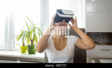 Porträt der schönen jungen Frau mit VR-Headset zu Hause Stockfoto