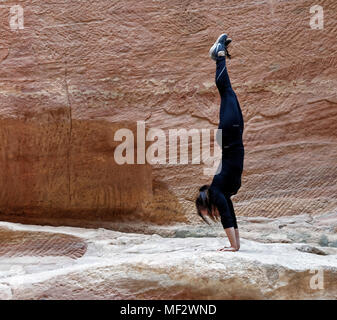 Petra, Wadi Musa, Jordanien, 9. März 2018: In der Nähe von einem jungen europäischen Mädchen Training einen Handstand im siq von Petra, Naher Osten Stockfoto