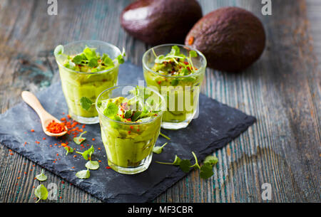 Gläser Avocadocreme mit Chili Flocken, Kresse und Petersilie Stockfoto