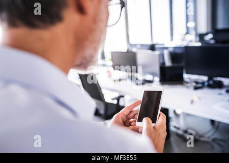 In der Nähe - upof Geschäftsmann in Office mit Smartphone Stockfoto