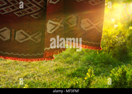 Traditionelle marokkanische Berber Teppich hängen im Freien in der Abendsonne. Stockfoto