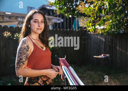 Porträt der jungen Frau mit dem Tattoo im Hinterhof Stockfoto