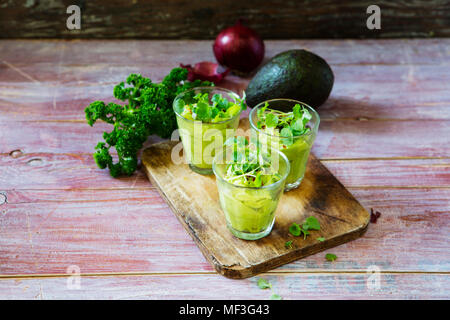 Gläser Avocadocreme mit Chili Flocken, Kresse und Petersilie Stockfoto