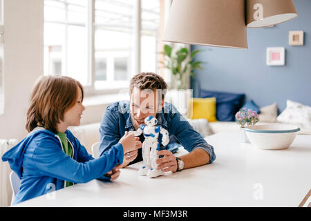 Gerne Vater und Sohn spielen mit Roboter auf dem Tisch zu Hause Stockfoto