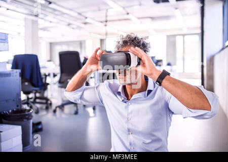 Reifen Geschäftsmann tragen VR-Brille im Büro Stockfoto