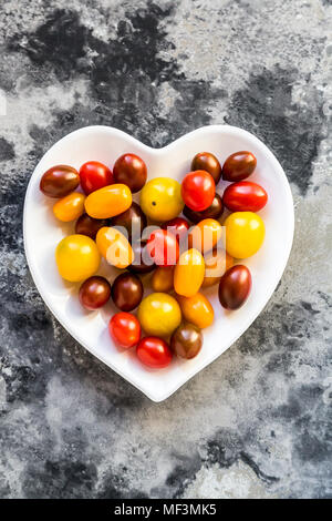 Herzförmige Schale mini Tomaten Stockfoto