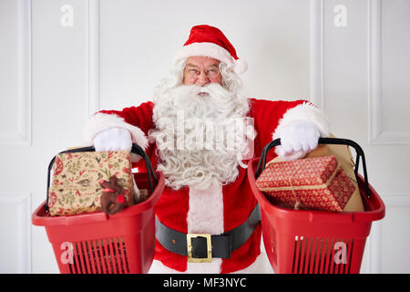 Portrait von Santa Claus hält zwei Warenkörbe mit Weihnachtsgeschenke Stockfoto