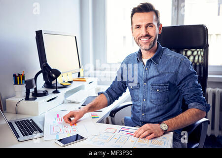 Portrait von lächelnden Web designer Arbeiten zum Entwurf am Schreibtisch im Büro Stockfoto