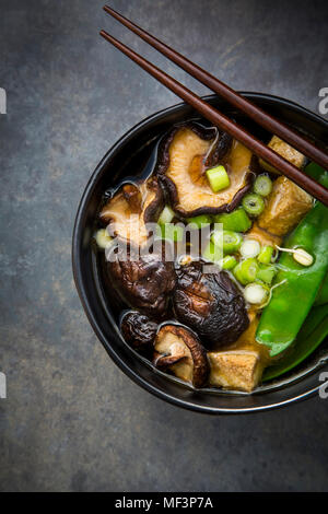 Japanische Miso Suppe mit Zuckererbsen, Shitake Pilze, Tofu und mung Sprossen Stockfoto