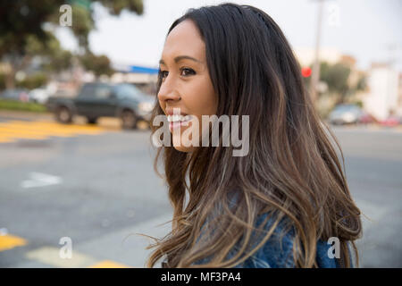 Portrait von lächelnden jungen Frau auf der Straße Stockfoto