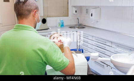 Ansicht von hinten Bild der Zahnarzt untersuchen Patienten Mundhöhle mit speziellen Instrumenten Stockfoto