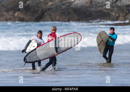 Die jungen Surfer zu Fuß aus dem Meer nach konkurrieren in einem longboard surfen Wettbewerb auf den Fistral in Newquay Cornwall. Fistral Beach; Newquay Cornwall Stockfoto