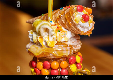 Caramel Marshmallow candy Milk Shake Cocktail mit Schlagsahne, Plätzchen, Waffeln und andere Leckereien Stockfoto