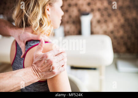 Nicht erkennbare Physiotherapeuten arbeiten mit einem weiblichen Patienten. Stockfoto