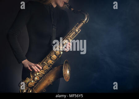 Saxophonist. Frau mit Saxophon auf einem dunklen Hintergrund Stockfoto