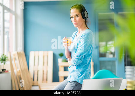 Frau Aufarbeitung ihrer neuen Heimat, Pause machen, Kaffee trinken und Musik hören Stockfoto