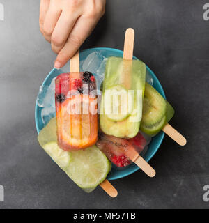 Woman's Hand, denn orange Beere popsicle Stockfoto