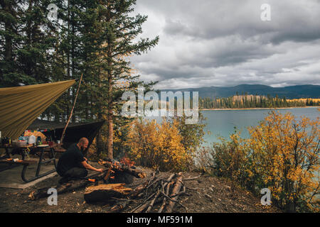 Kanada, British Columbia, Mann, Lagerfeuer bei Boya Lake Stockfoto