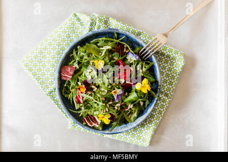 Schüssel mit Salat, Feldsalat, Rucola, Radicchio und essbaren Blüten Stockfoto