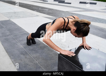 Passende Frau tun Push-ups im Freien Stockfoto