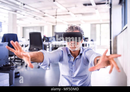 Gerne reife Geschäftsmann tragen VR-Brille im Büro Stockfoto