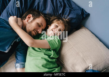 Vater und Sohn zu Hause kuscheln Stockfoto