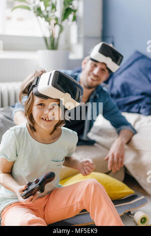 Portrait von Happy Boy und Vater tragen VR-Brille spielen video Spiel zu Hause Stockfoto