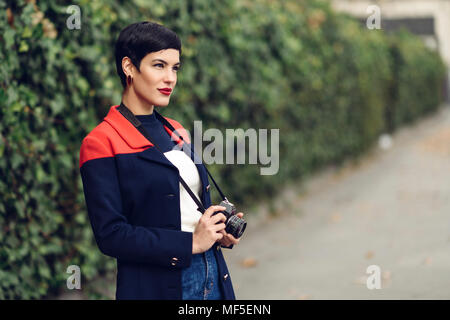 Portrait von modische junge Frau mit Kamera Stockfoto