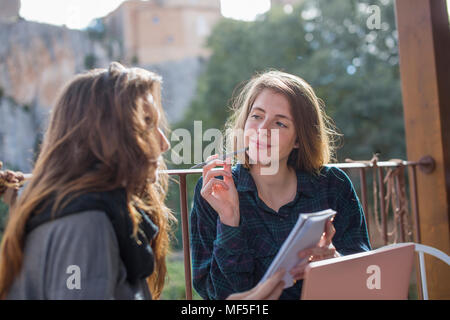 Portrait von lächelnden jungen Frau, die auf der Terrasse Stockfoto