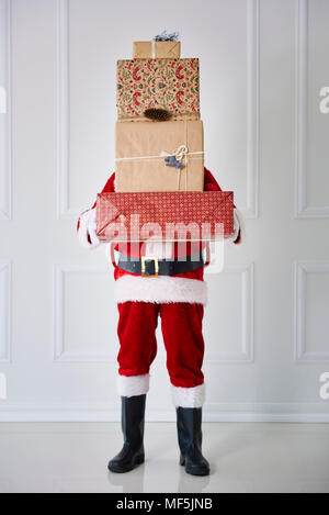 Santa Claus Holding von Weihnachtsgeschenken Stapel Stockfoto